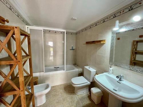 Un baño con inodoro, lavabo y bañera. en Apartamento Panorama X0089, en Benitachell