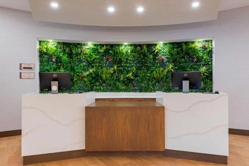 un ufficio con una parete verde e due monitor di Cambria Hotel Shelby Township - Detroit Utica a Shelby