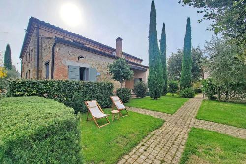 a garden with two chairs and a building at Il Palazzo dei Diavoli in Montepulciano