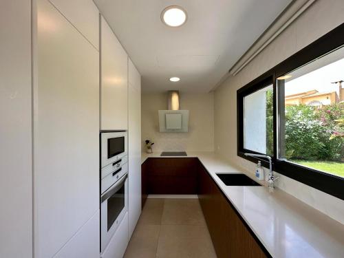 Una pequeña cocina con fregadero y ventana. en Villa Amanecer, en Benitachell