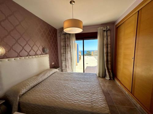 ベニタチェルにあるVilla Paraísoのベッドと大きな窓のある寝室
