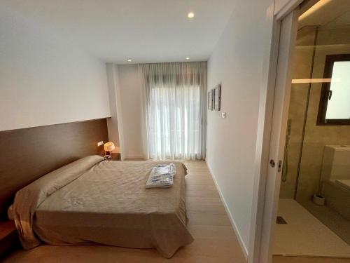 Un dormitorio con una cama y una ducha a ras de suelo. en Villa Amanecer, en Benitachell