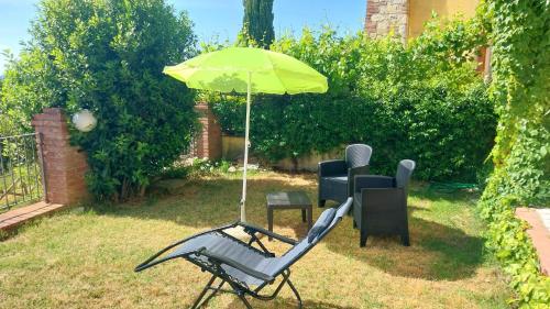 a couple of chairs and an umbrella in a yard at La Bella Vista in Collazzone