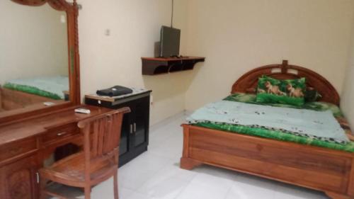 a bedroom with a bed and a desk and a mirror at Lagura Residence in Jakarta