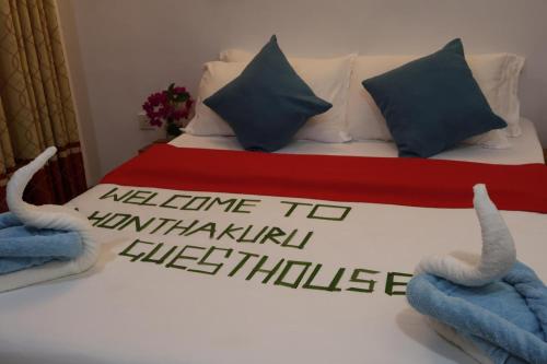 a bedroom with a bed with two towels on it at Dhontakuru Guest House in Ariyaddu