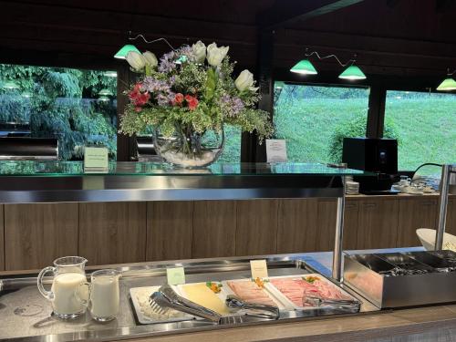 a restaurant counter with a vase of flowers on it at Bungalows Korana - Campsite Korana in Seliste Dreznicko