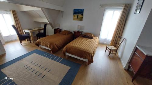 a bedroom with two beds and a desk and windows at Chambres d'Hôtes L'Insulaire in Saint-Denis-dʼOléron