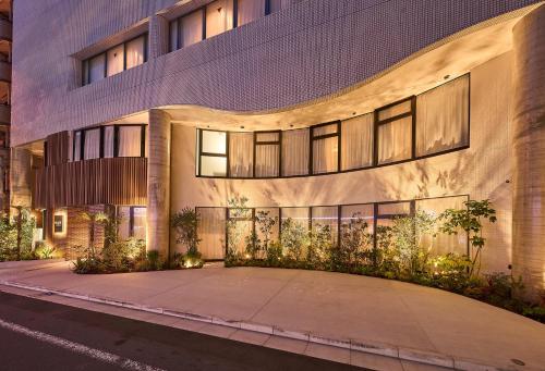 an exterior view of a building at night at GRAND HOSTEL LDK Tokyo Nishikasai -GRAND OPENING In May 2025- in Tokyo