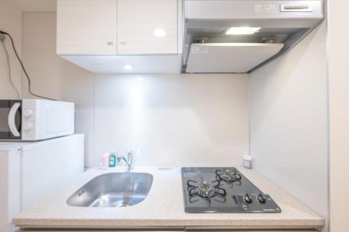 a kitchen with a sink and a microwave at Grand Concierge Roppongi in Tokyo