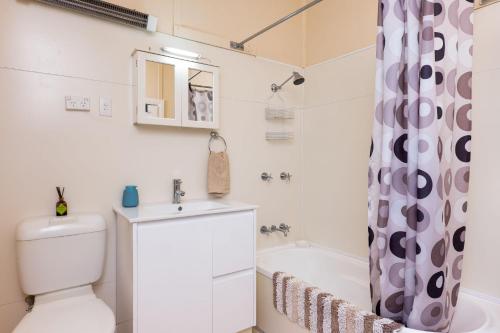 a bathroom with a toilet and a sink and a tub at Crooked Cottage in Nambucca Heads