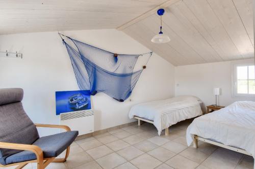 a bedroom with a bed and a net on the wall at 500 m de la plage - Maison pour 6 - Terrasse in LʼÉpine