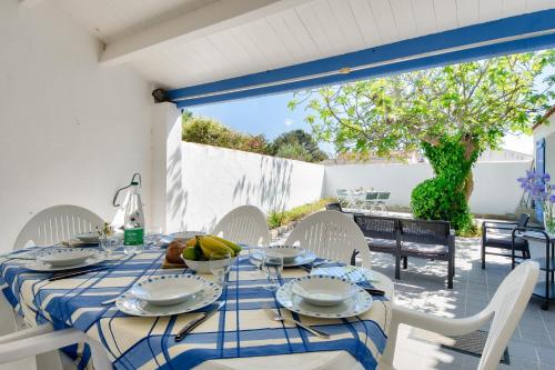 une salle à manger avec une table et des chaises ainsi qu'une terrasse dans l'établissement 500 m de la plage - Maison pour 6 - Terrasse, à LʼÉpine