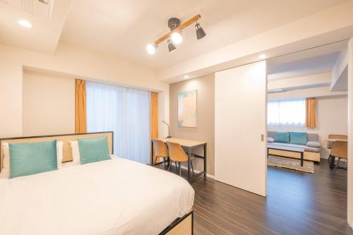 a bedroom with a bed and a desk in a room at Grand Concierge Roppongi in Tokyo