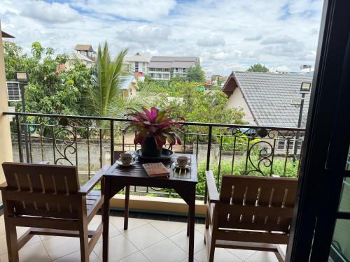 a table and two chairs on a balcony with a view at Laph Kham House in Chiang Mai