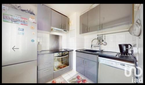 une cuisine avec un évier et un réfrigérateur dans l'établissement Chambre chez raissa, à Trappes