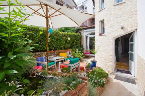 un jardín con mesa, sillas y sombrilla en Guest House More, en Rijeka