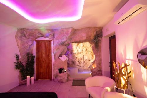 a room with a rock wall and purple lighting at Kira suite and rooms in Pozzuoli