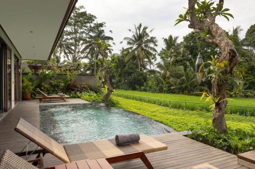 a backyard with a swimming pool and a garden at Inara Alas Harum in Ubud