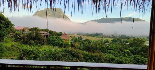 a view from a window of a misty mountain valley at Baan 2 Dao Farmstay in Chiang Dao