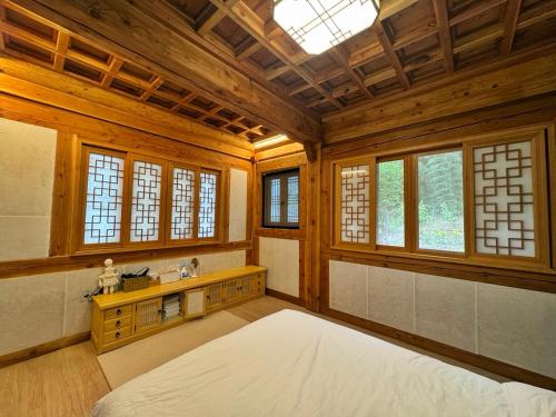 a large bedroom with a large bed and windows at Hanok Stay - JukRokJungSa in Gurye