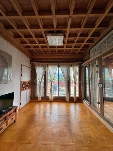 an empty room with wooden floors and large windows at Hanok Stay - JukRokJungSa in Gurye