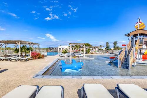 un parc aquatique avec un toboggan et une aire de jeux dans l'établissement L'Oasis des Pins, à Sète
