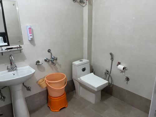 un baño con inodoro y lavabo en Bir Hotel by Aaroh, en Bīr