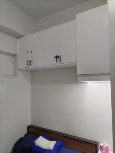 a room with white cabinets and a blue bed at Paranaque Manila Bloom residences in Manila