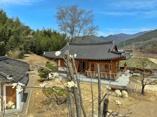 a house with a mountain in the background at Hanok Stay - JukRokJungSa in Gurye