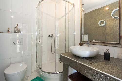 a bathroom with a sink and a toilet and a shower at Guest House More in Rijeka