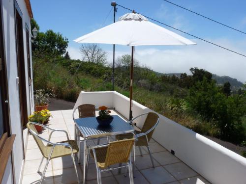 eine Terrasse mit Tisch und Stühlen und einem Sonnenschirm in der Unterkunft Ferienhaus für 3 Personen und 1 Kind in Puntagorda, La Palma in Puntagorda