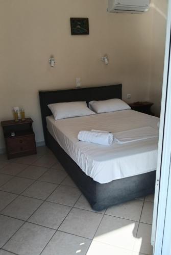 a bed with white sheets and pillows in a bedroom at Galini Studios in Sivota