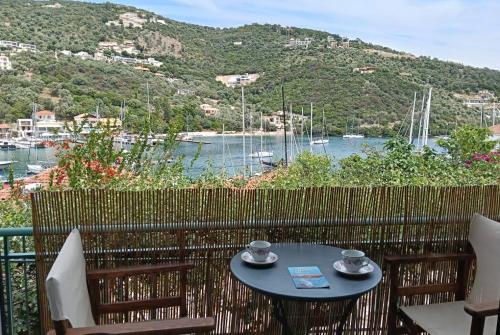 a table on a balcony with a view of a harbor at Galini Studios in Sivota