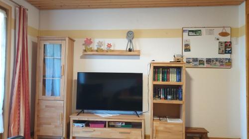 a flat screen tv sitting on a wooden entertainment center at Wohnung Fübüüni in Wittenschwand