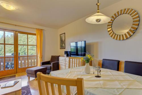 a dining room with a table and a mirror at Siebensteinkopf in Spiegelau