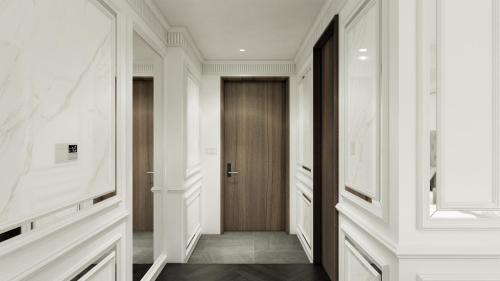 a hallway with white walls and a wooden door at The Siena PRIMO in Seogwipo