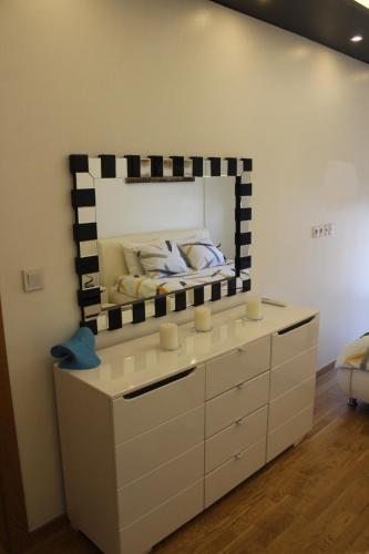 サラエボにあるLuxury Apartment Jennyのドレッサーの上に大きな鏡がある寝室