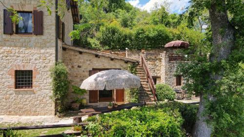 ein Steinhaus mit einer Treppe und einem Regenschirm in der Unterkunft Ferienhaus für 10 Personen in Penna San Giovanni, Marken Provinz Macerata in Penna San Giovanni