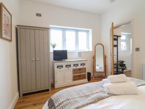 a bedroom with a bed and a window and a mirror at Highview Stables in Chesterfield