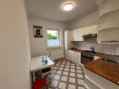 a kitchen with white cabinets and a sink and a window at Home4you Katowice in Katowice