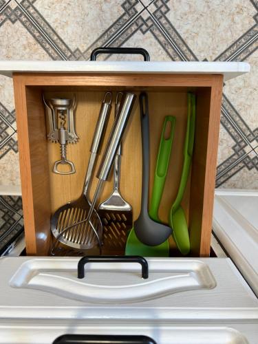 a drawer full of kitchen utensils in a refrigerator at Home4you Katowice in Katowice