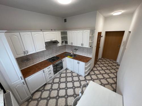 a small kitchen with white cabinets and a sink at Home4you Katowice in Katowice