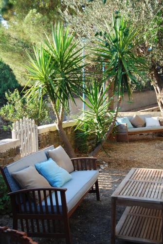 a couch and two chairs and a table and palm trees at Spiti Limnos, Idyllisch Gelegen Im Orangenhain in Límnos
