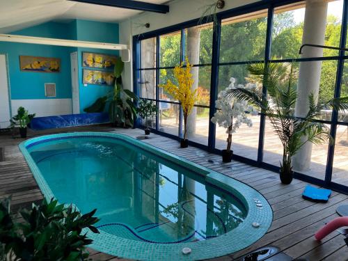 une piscine intérieure dans une maison avec des fenêtres dans l'établissement Ar Couette, au Bono