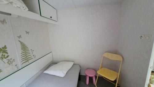 a small room with a small bed and a chair at Mobile home toutes saisons in Beauzac