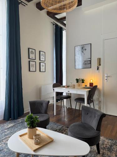un salon avec une table et des chaises blanches dans l'établissement Quartier Vieux Tours, Grand studio avec coin chambre, à Tours