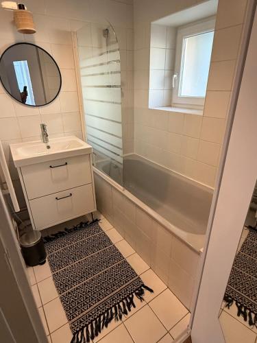 une salle de bain avec un lavabo, une baignoire et un miroir dans l'établissement Quartier Vieux Tours, Grand studio avec coin chambre, à Tours