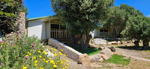 une maison avec un mur de soutènement en pierre dans un jardin dans l'établissement Grande Chambre tout confort 4, à Bonifacio