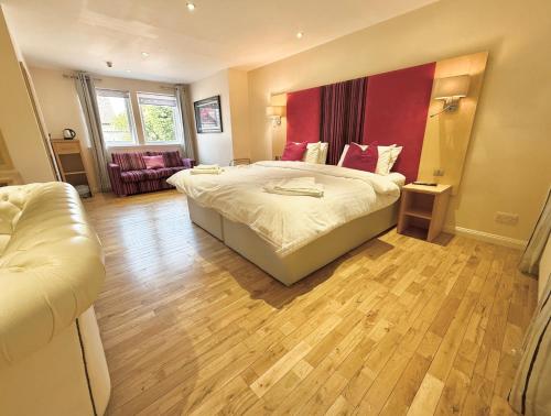 a bedroom with a large bed with a red wall at The Clubhouse Nairn in Nairn