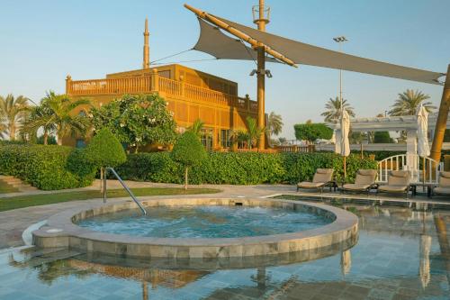 a small pool with chairs and a building in the background at The St. Regis Abu Dhabi in Abu Dhabi